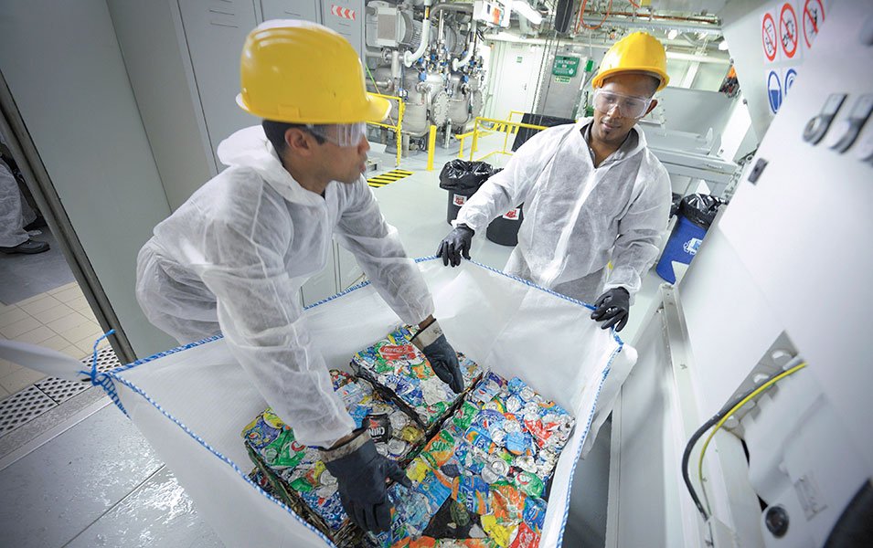 Crew members sorting compacted recyclables in a waste management facility onboard | MSC Cruises Crew members sorting compacted recyclables in a waste management facility onboard | MSC Cruises