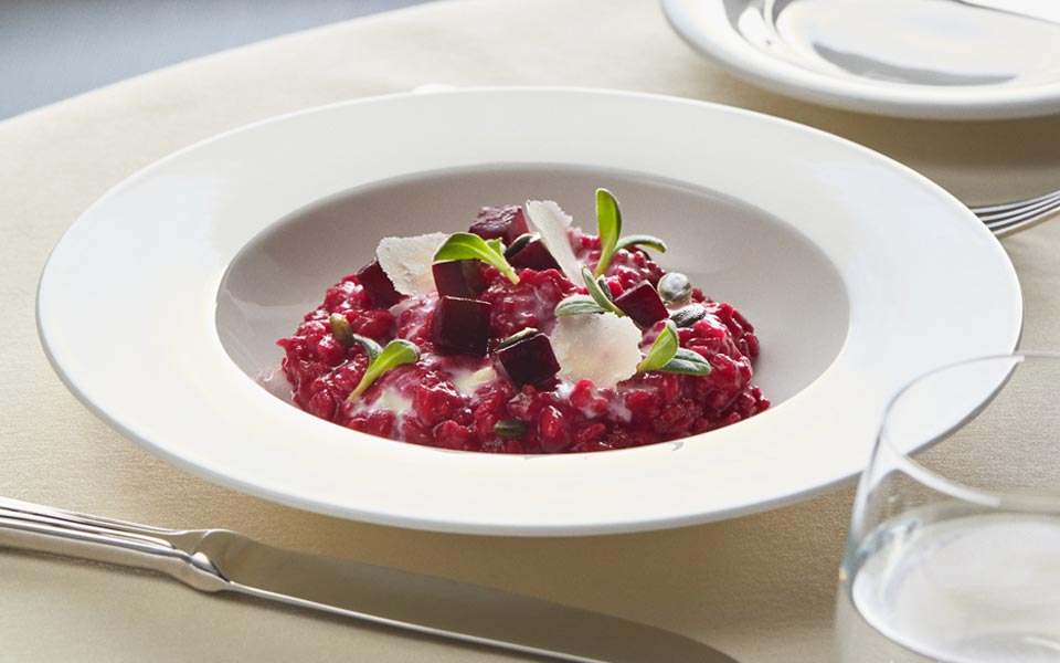 Gourmet beetroot risotto garnished with fresh herbs and parmesan shavings | MSC Cruises