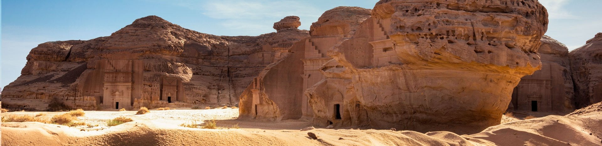 Ancient rock-carved tombs in a desert landscape under a clear blue sky | MSC Cruises Ancient rock-carved tombs in a desert landscape under a clear blue sky | MSC Cruises