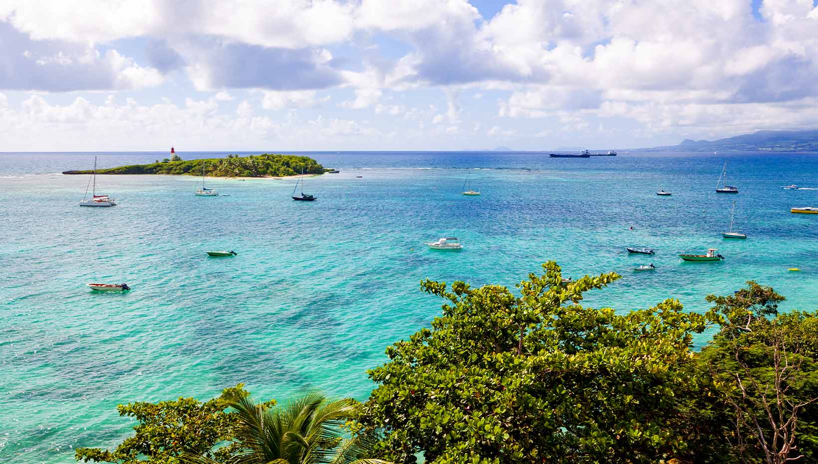 Turquoise waters with sailboats near a tropical island | MSC Cruises