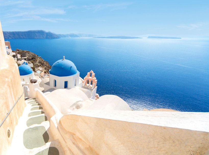 Santorini's iconic blue-domed churches overlooking the Aegean Sea | MSC Cruises