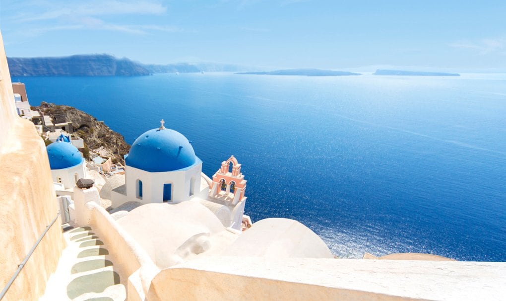 Santorini's iconic blue-domed churches overlooking the Aegean Sea | MSC Cruises Santorini's iconic blue-domed churches overlooking the Aegean Sea | MSC Cruises