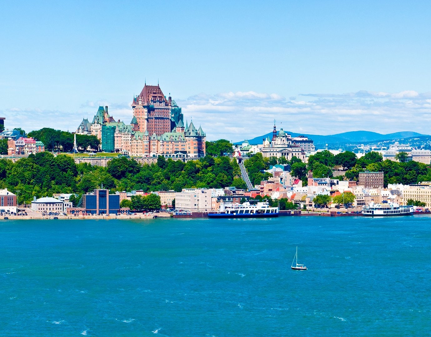 Quebec City's Château Frontenac overlooking the St. Lawrence River with a sailboat in the foreground | MSC Cruises Quebec City's Château Frontenac overlooking the St. Lawrence River with a sailboat in the foreground | MSC Cruises