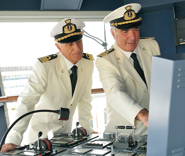 Two ship captains in white uniforms at the cruise ship's control panel | MSC Cruises