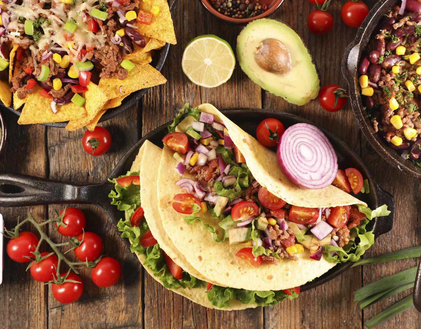 Mexican cuisine with tacos, nachos, and fresh ingredients on a wooden table | MSC Cruises Mexican cuisine with tacos, nachos, and fresh ingredients on a wooden table | MSC Cruises