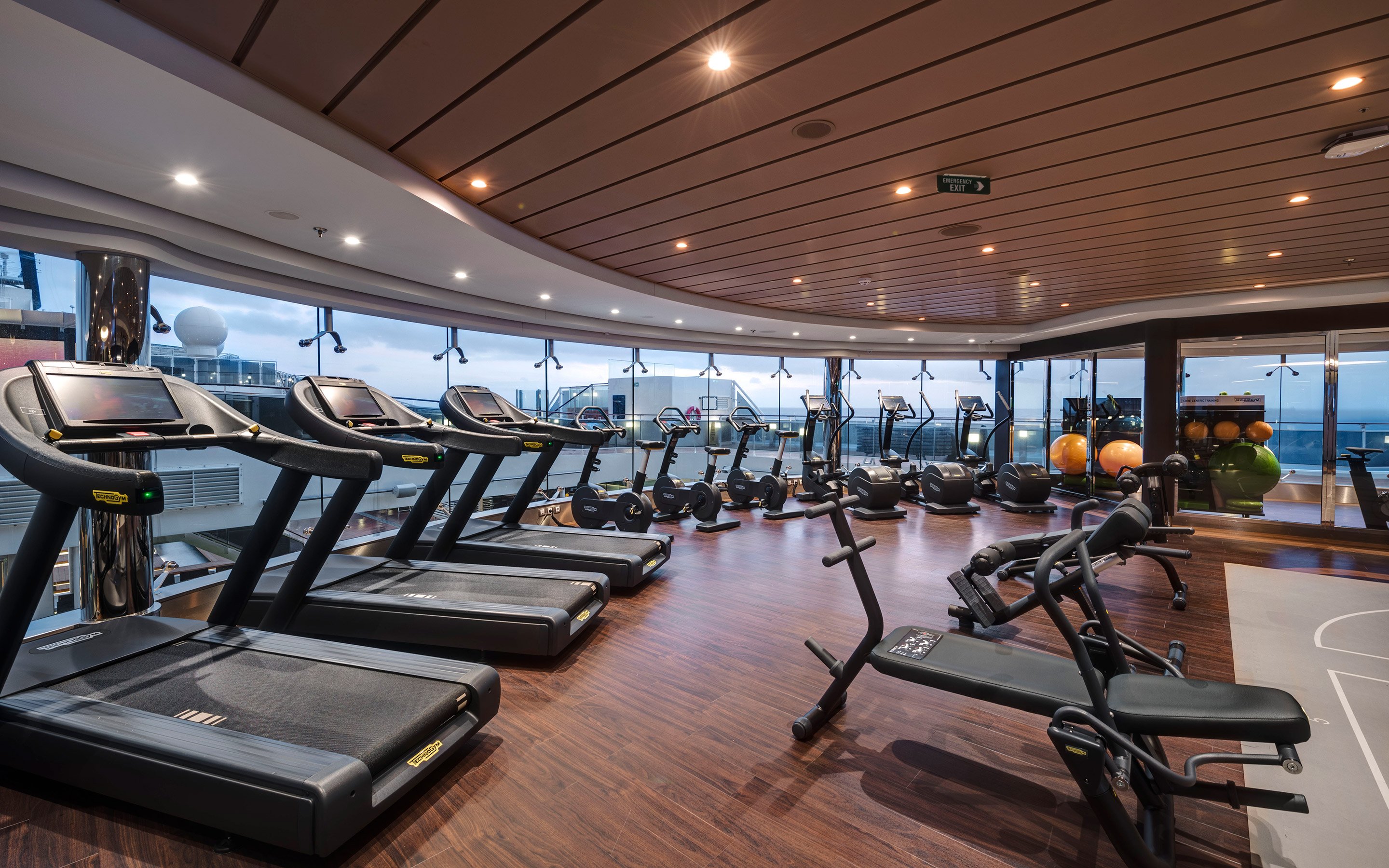 Modern fitness center with treadmills and exercise equipment overlooking the ocean | MSC Cruises