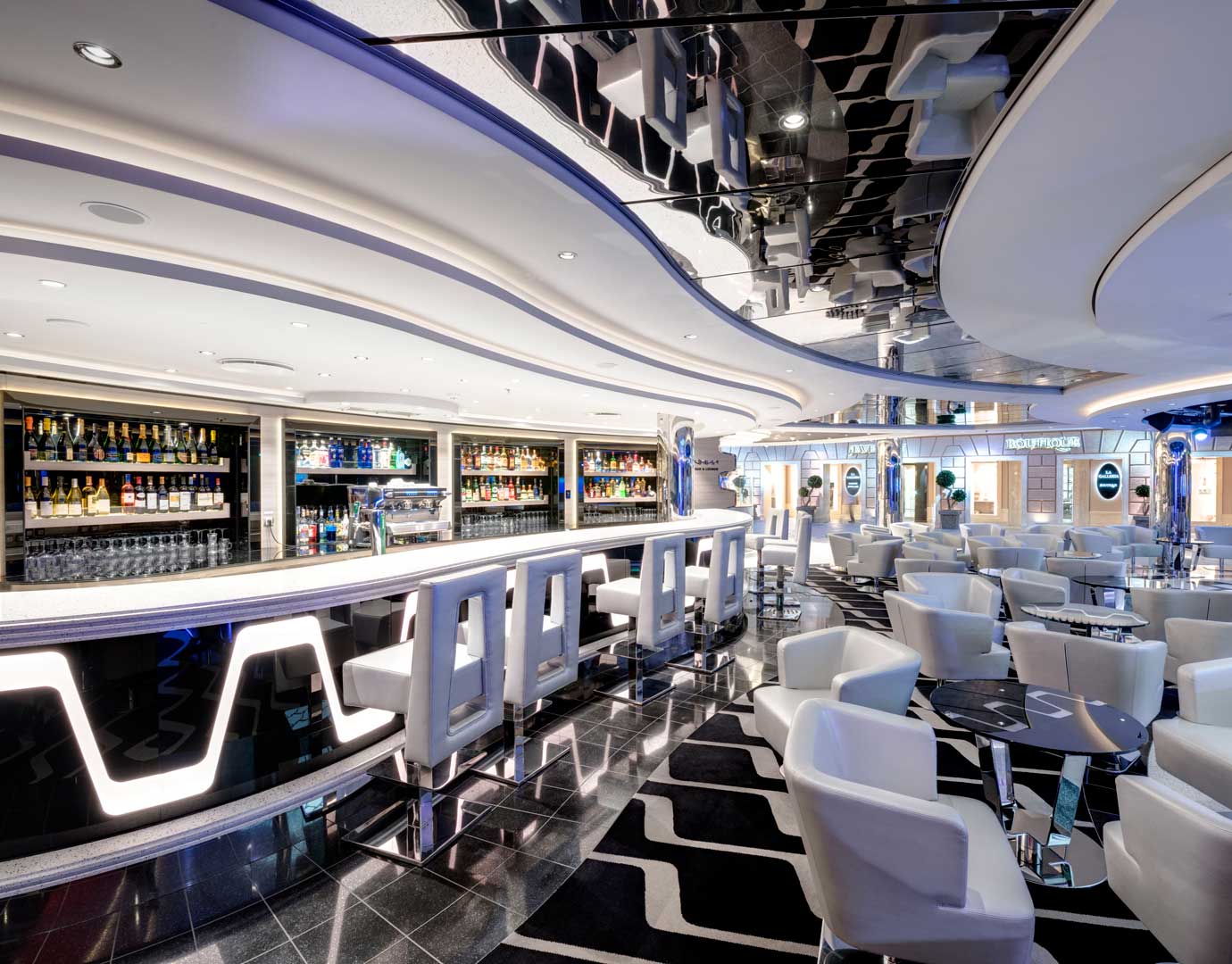 Modern onboard bar with illuminated counter, stylish seating, and a wide selection of drinks | MSC Cruises
