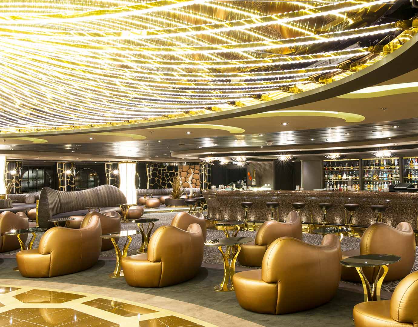 Luxurious cruise ship lounge with golden decor and modern seating | MSC Cruises
