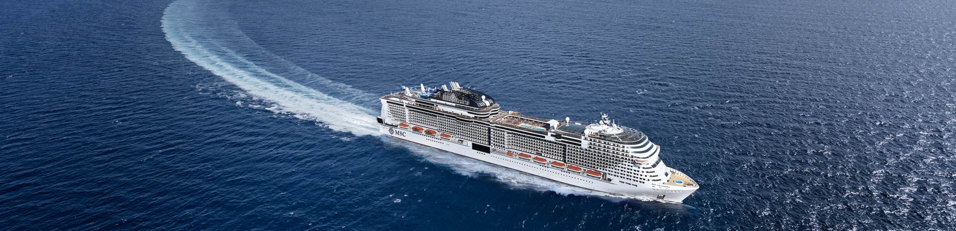An MSC cruise ship sailing through calm blue ocean waters | MSC Cruises An MSC cruise ship sailing through calm blue ocean waters | MSC Cruises