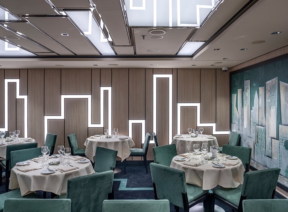Elegant cruise ship dining room with modern decor and teal seating | MSC Cruises Elegant cruise ship dining room with modern decor and teal seating | MSC Cruises