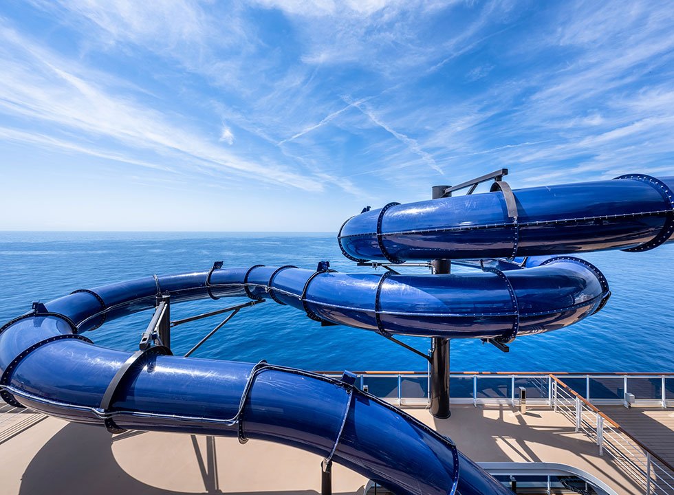 A twisting blue waterslide on a cruise ship deck with ocean views | MSC Cruises A twisting blue waterslide on a cruise ship deck with ocean views | MSC Cruises