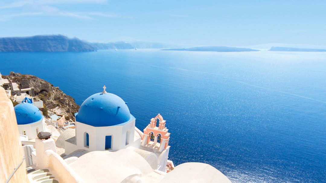 Iconic blue-domed buildings overlooking the Aegean Sea in Santorini | MSC Cruises Iconic blue-domed buildings overlooking the Aegean Sea in Santorini | MSC Cruises