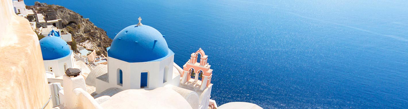 Santorini's iconic blue-domed churches overlooking the Aegean Sea | MSC Cruises Santorini's iconic blue-domed churches overlooking the Aegean Sea | MSC Cruises