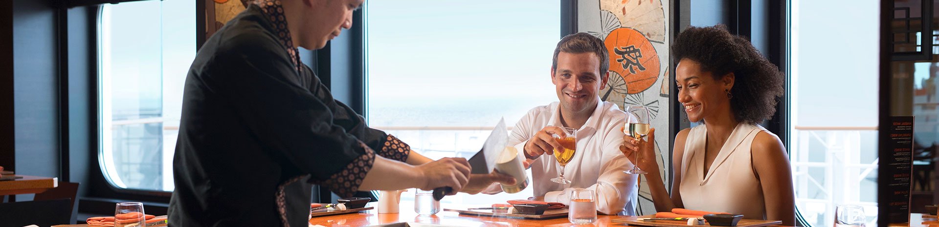 Guests enjoying a teppanyaki dining experience with ocean views | MSC Cruises Guests enjoying a teppanyaki dining experience with ocean views | MSC Cruises